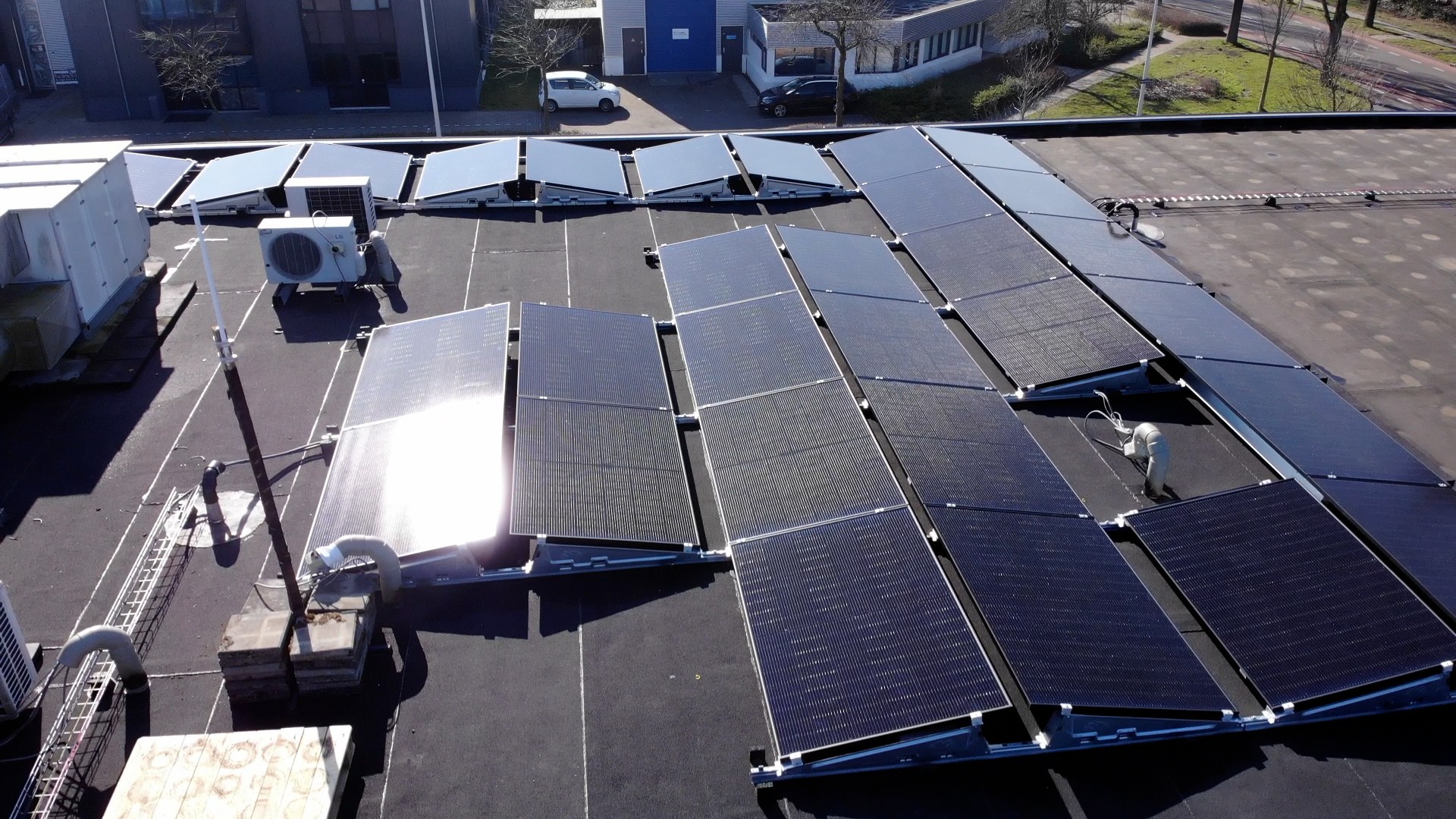 Zonnepanelen op een platte dak in oost-west opstelling.