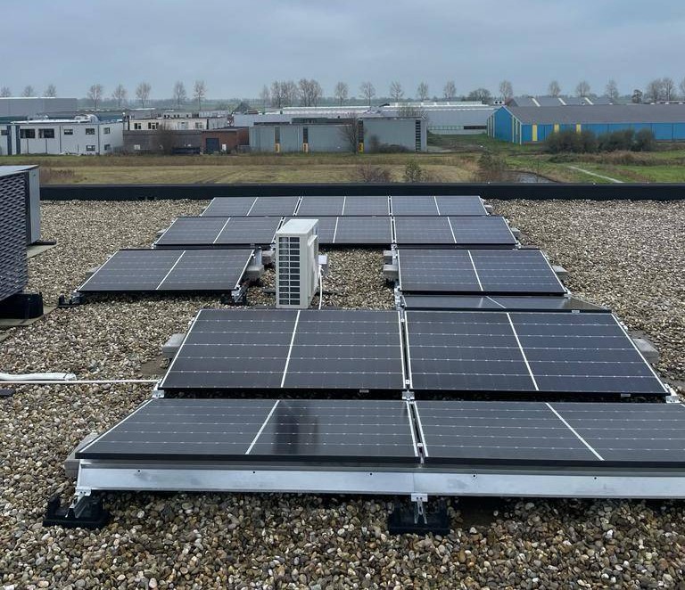 Zonnepanelen op een platte dak in een oost-west opstelling.