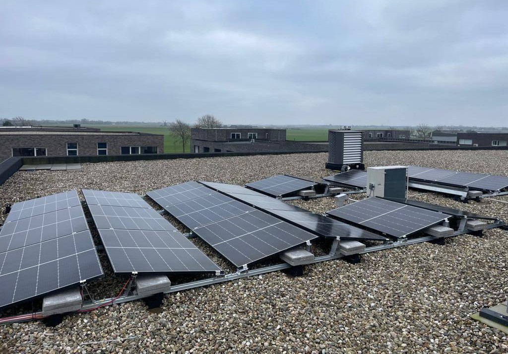 Zonnepanelen op een platte dak in een oost-west opstelling.