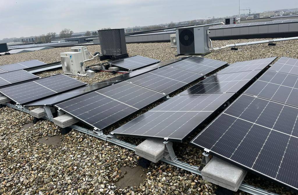 Zonnepanelen op een platte dak in een oost-west opstelling.