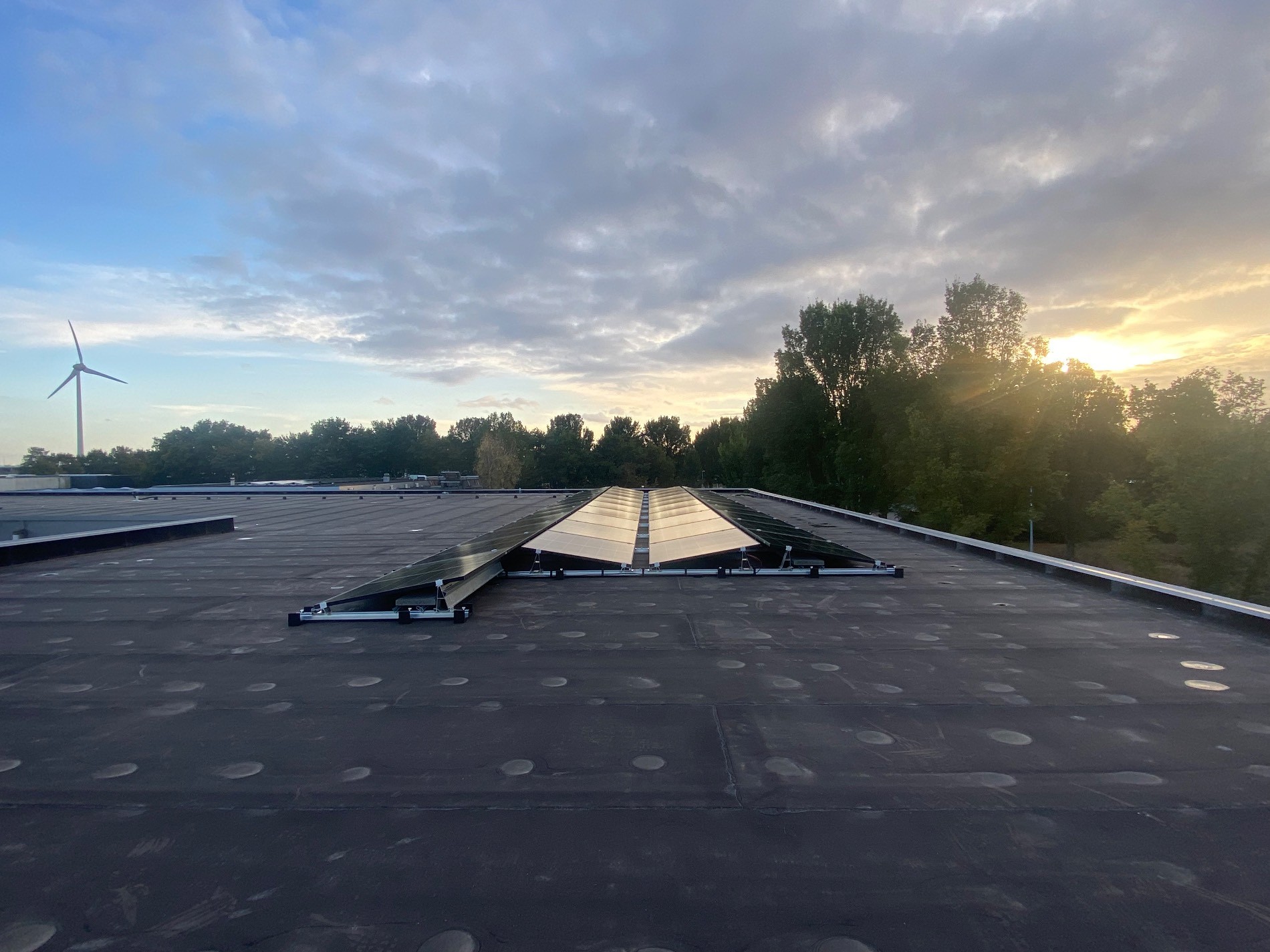 Zonnepanelen op een platte dak in een oost-west opstelling.