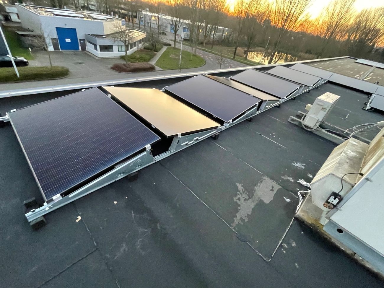 Zonnepanelen op een platte dak in een oost-west opstelling.