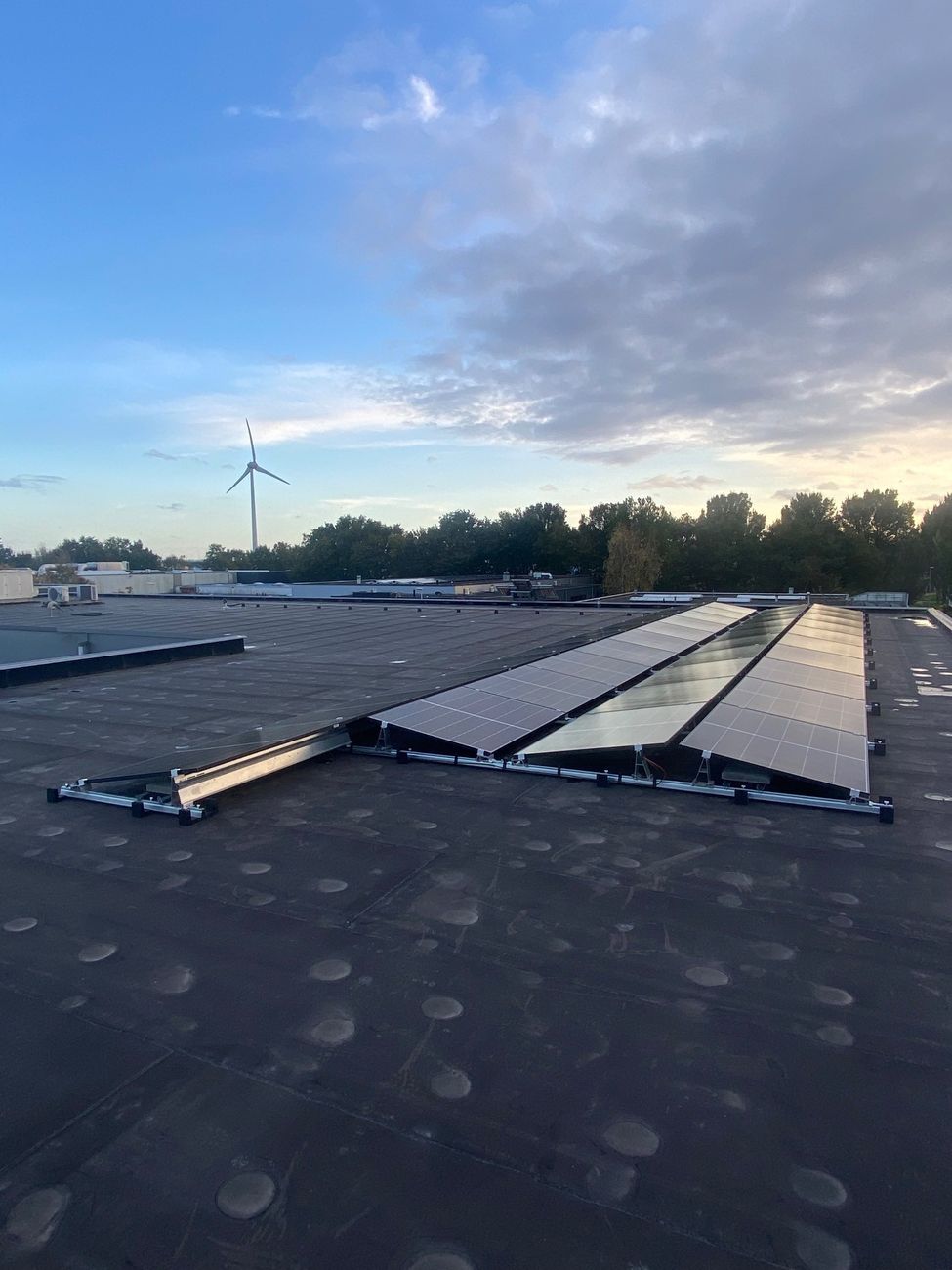 Zonnepanelen op een platte dak in een oost-west opstelling.