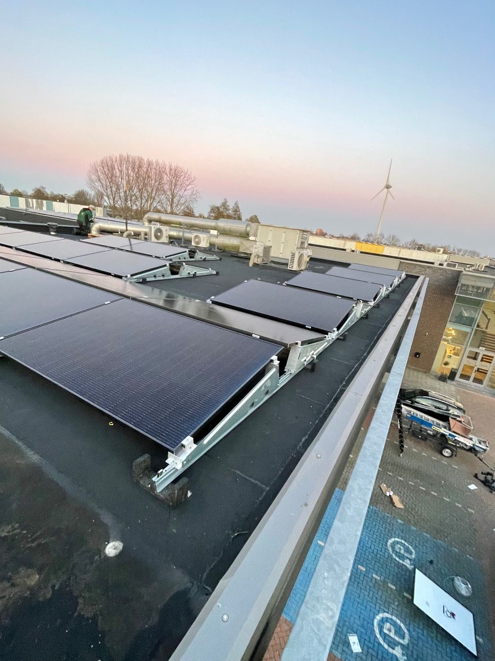 Zonnepanelen op een platte dak in een oost-west opstelling.