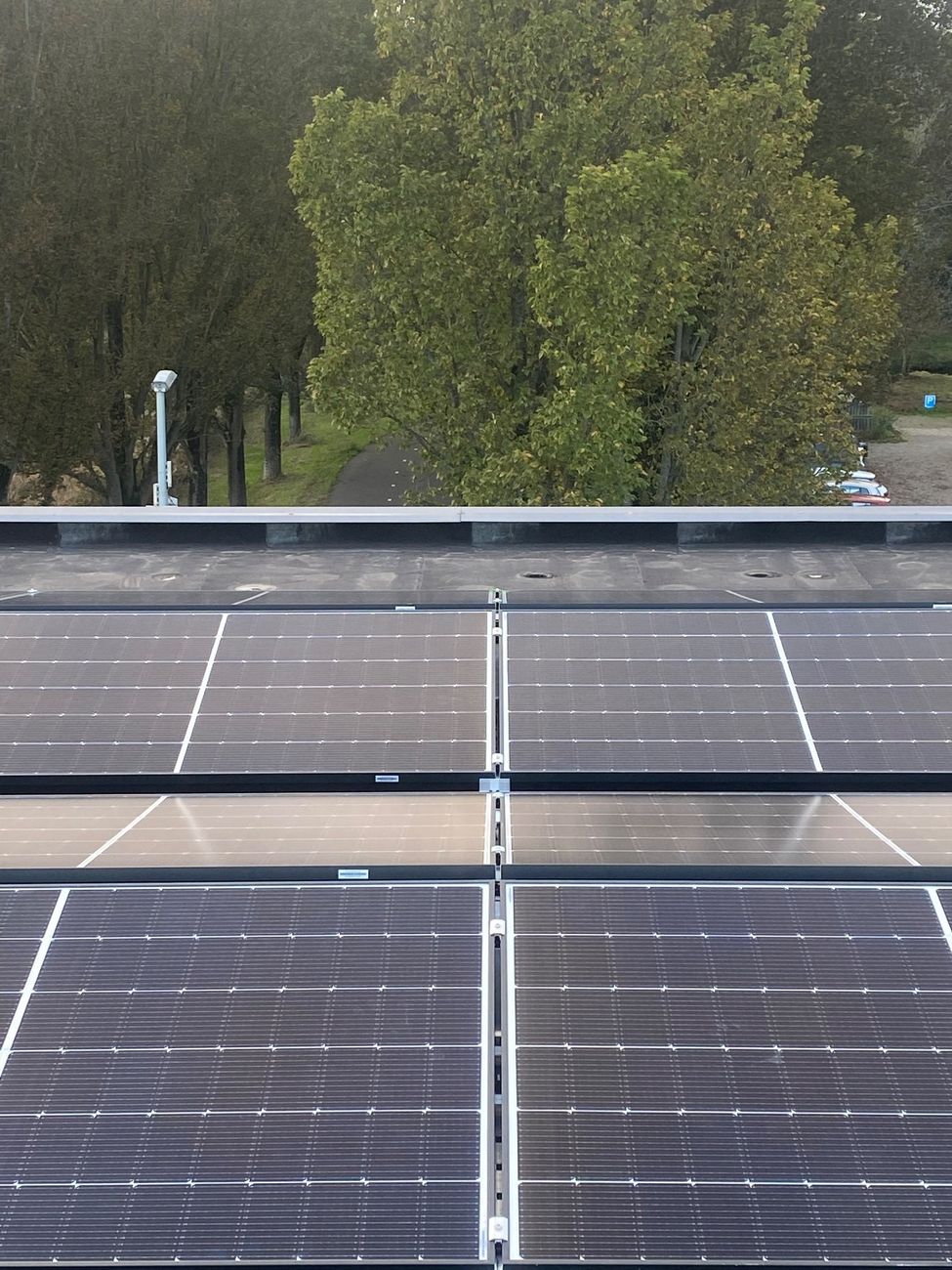 Zonnepanelen op een platte dak in een oost-west opstelling.