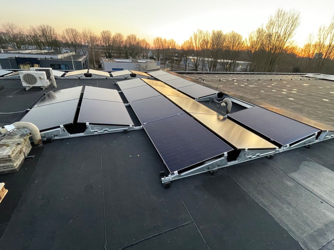 Zonnepanelen op een platte dak in een oost-west opstelling.