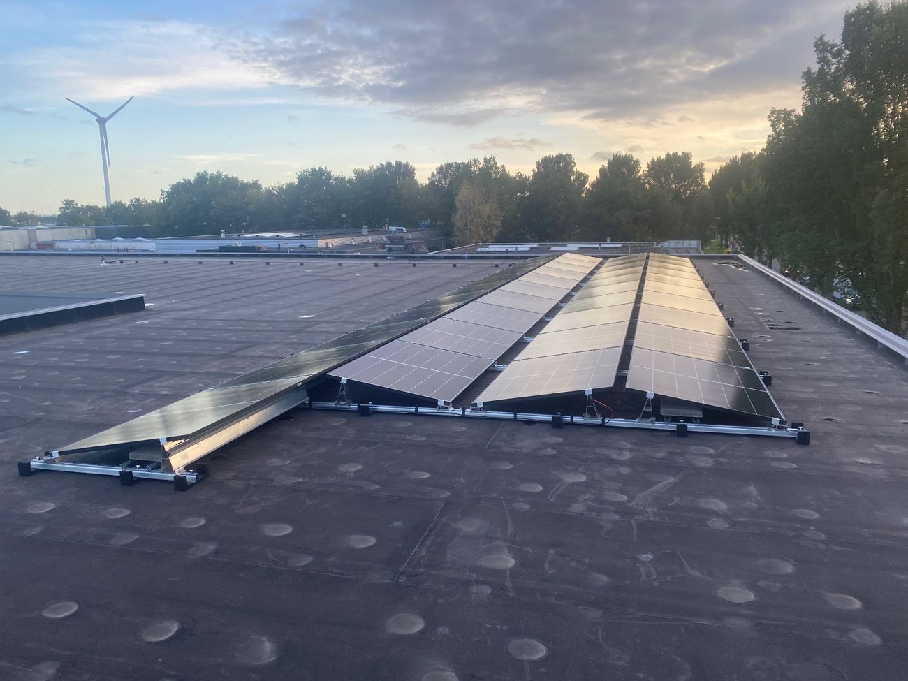 Zonnepanelen op een platte dak in een oost-west opstelling.