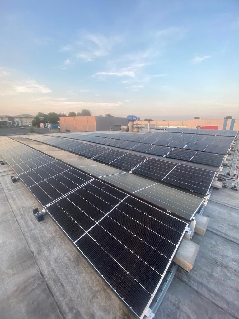 Zonnepanelen op een platte dak in een oost-west opstelling.