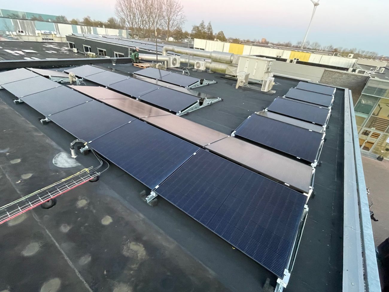 Zonnepanelen op een platte dak in een oost-west opstelling.