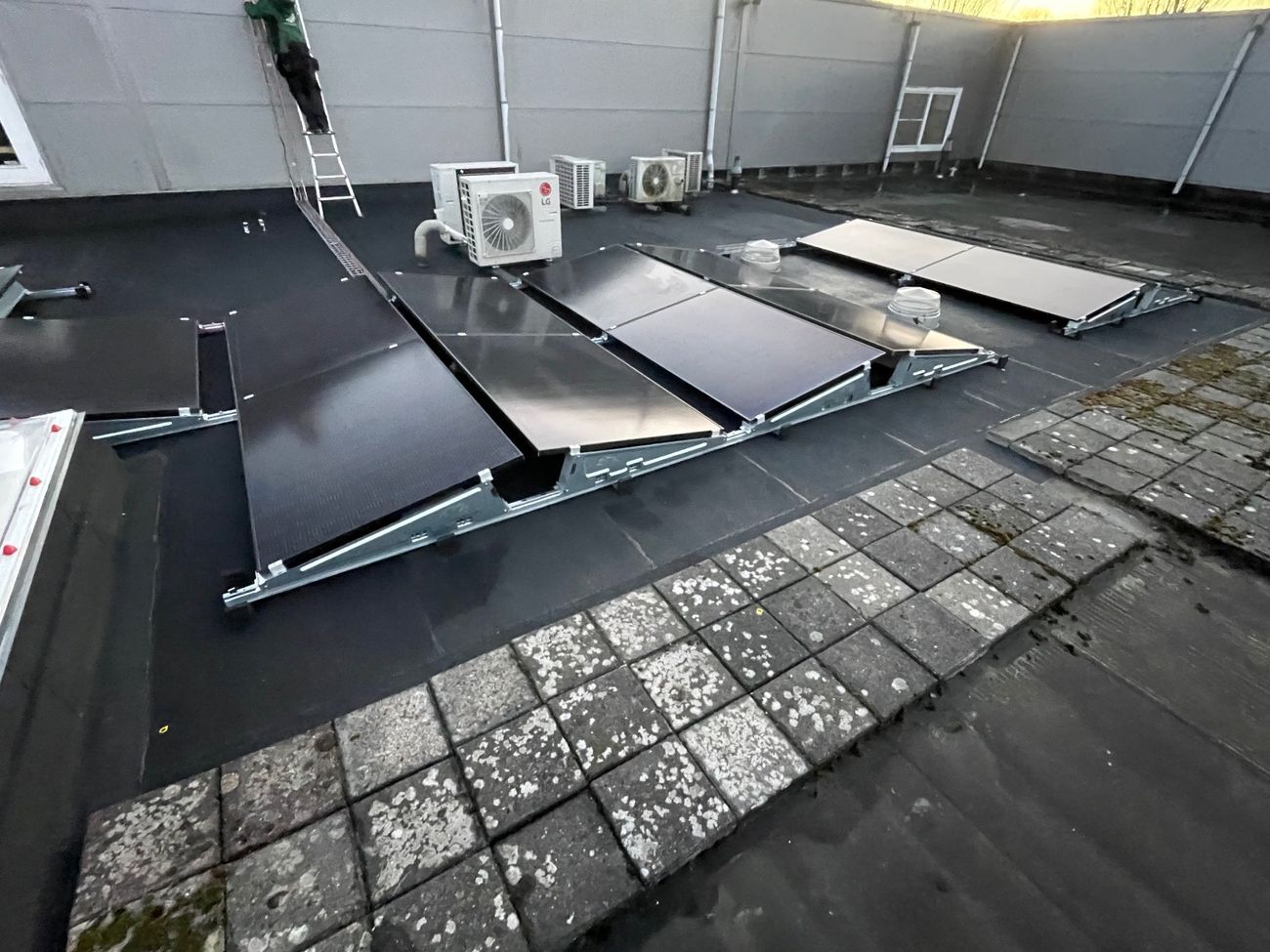 Zonnepanelen op een platte dak in een oost-west opstelling.