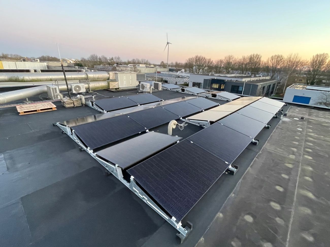 Zonnepanelen op een platte dak in een oost-west opstelling.