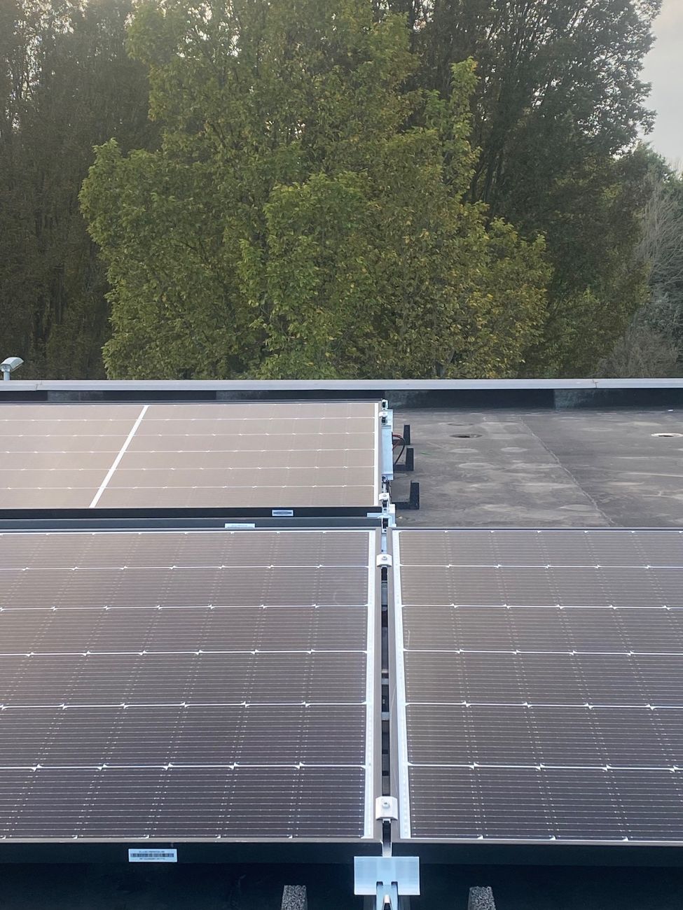 Zonnepanelen op een platte dak in een oost-west opstelling.